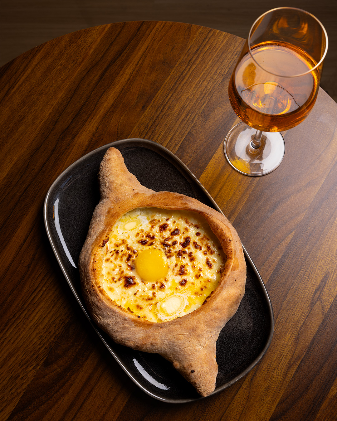 Acharuli khachapuri with egg, served with wine